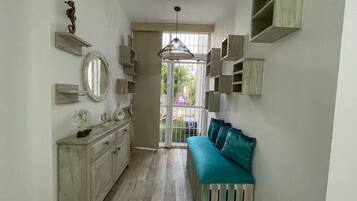 A narrow hallway with a bench, a mirror, and a seahorse decoration.