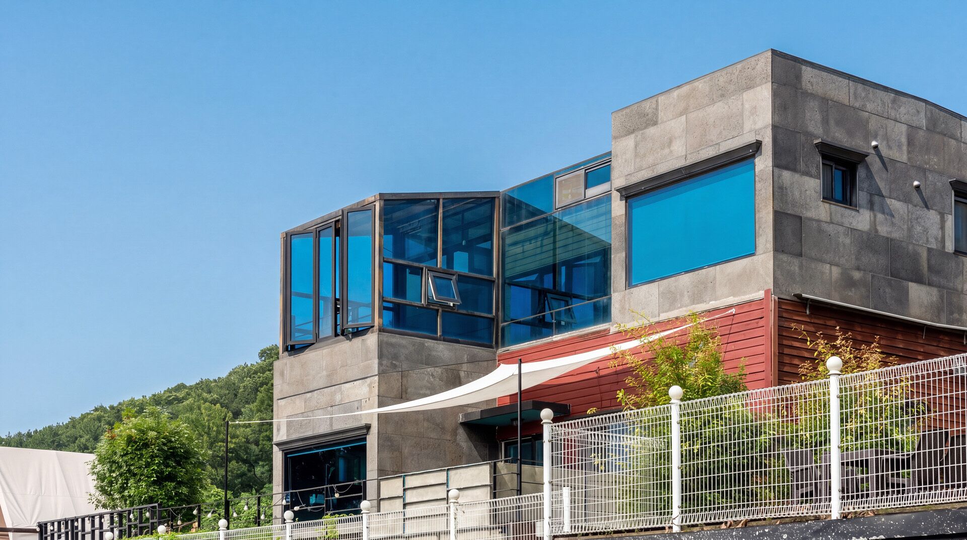 A modern building with large windows and a red facade.