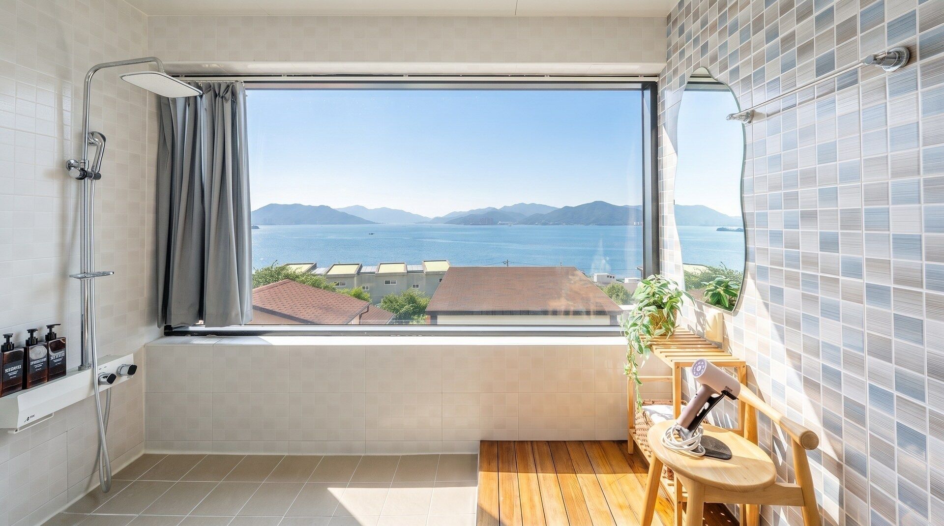 A bathroom with a large window, a shower, a wooden bench, and a potted plant.