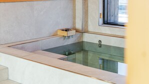 A modern bathroom with a glass-enclosed shower, a wooden medicine cabinet, and a window providing natural light. - Gyeongju Sanmaru Pension (Gyeongju)