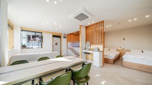 A modern hotel room with a dining area, a small kitchen, and a separate sleeping area. - Gyeongju Sanmaru Pension (Gyeongju)