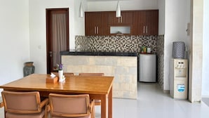 Una cocina moderna con una isla central, armarios de madera y microondas integrado.