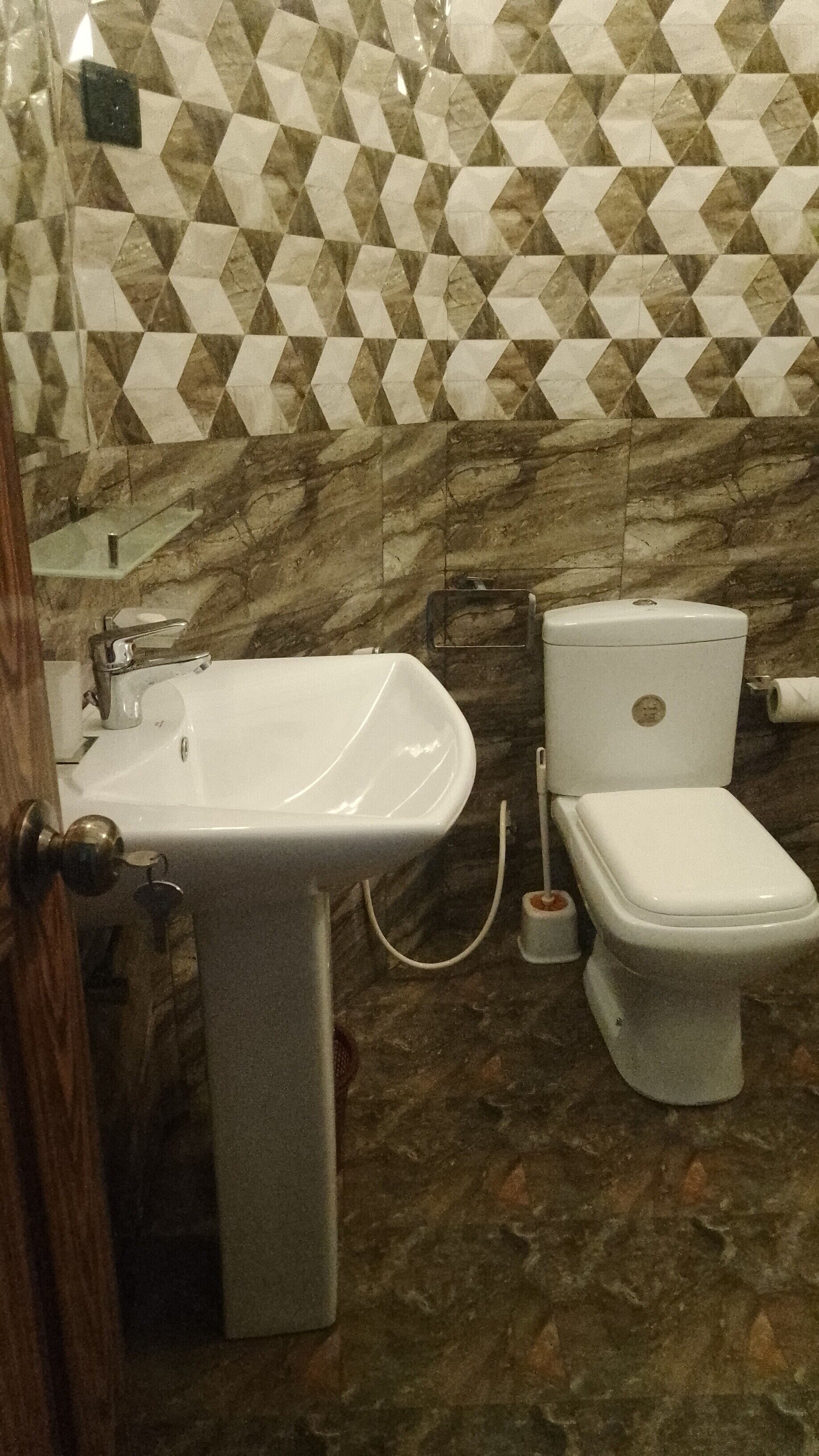 Un baño con lavamanos, inodoro y azulejos de diseño.