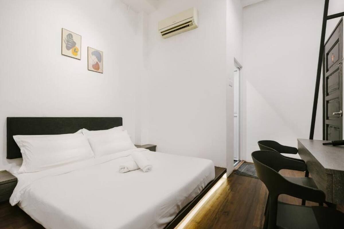 Une chambre d’hôtel avec un lit, un bureau et deux chaises.