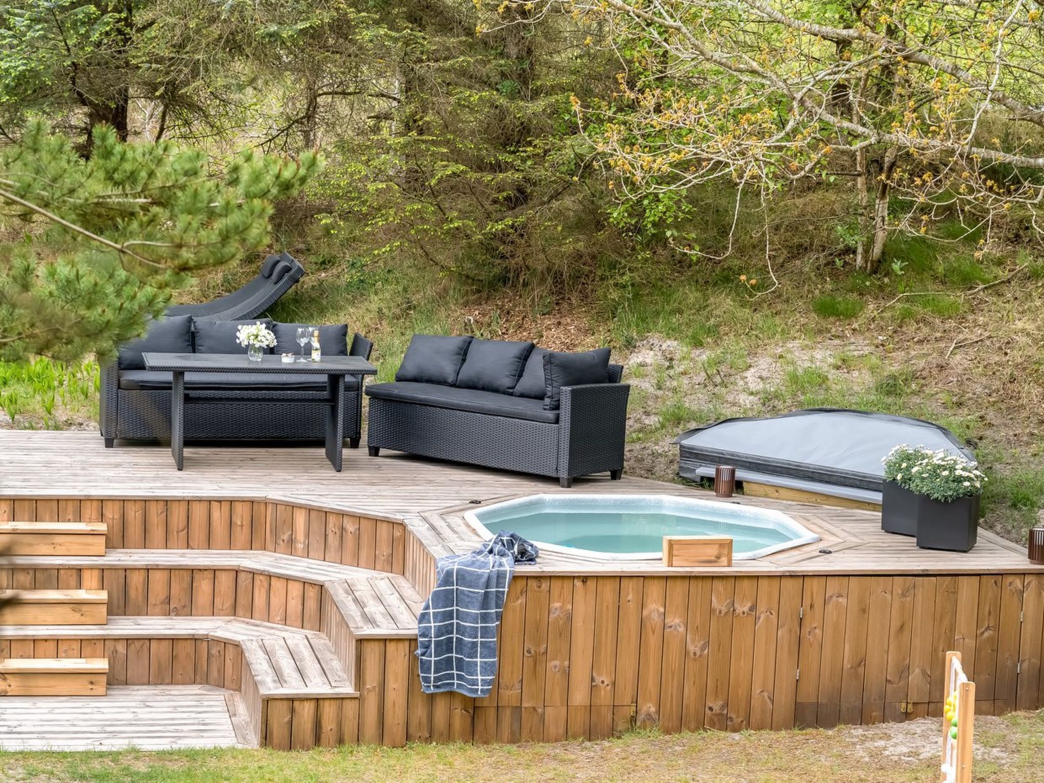 A deck with outdoor furniture, a hot tub, and a pool.
