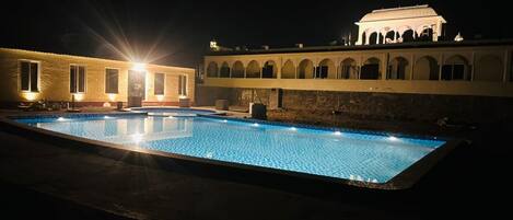 Ein Schwimmbecken mit einem Gebäude im Hintergrund.