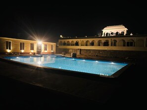 A swimming pool with a building in the background. - Vardhan Resorts (Nawalgarh)