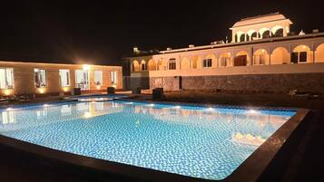 Una piscina al aire libre, sombrillas, tumbonas