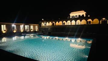 Una piscina al aire libre, sombrillas, tumbonas
