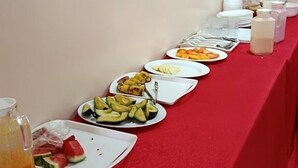A buffet table with various food items and a pitcher of juice. - Becca Hotel Meru (Meru)