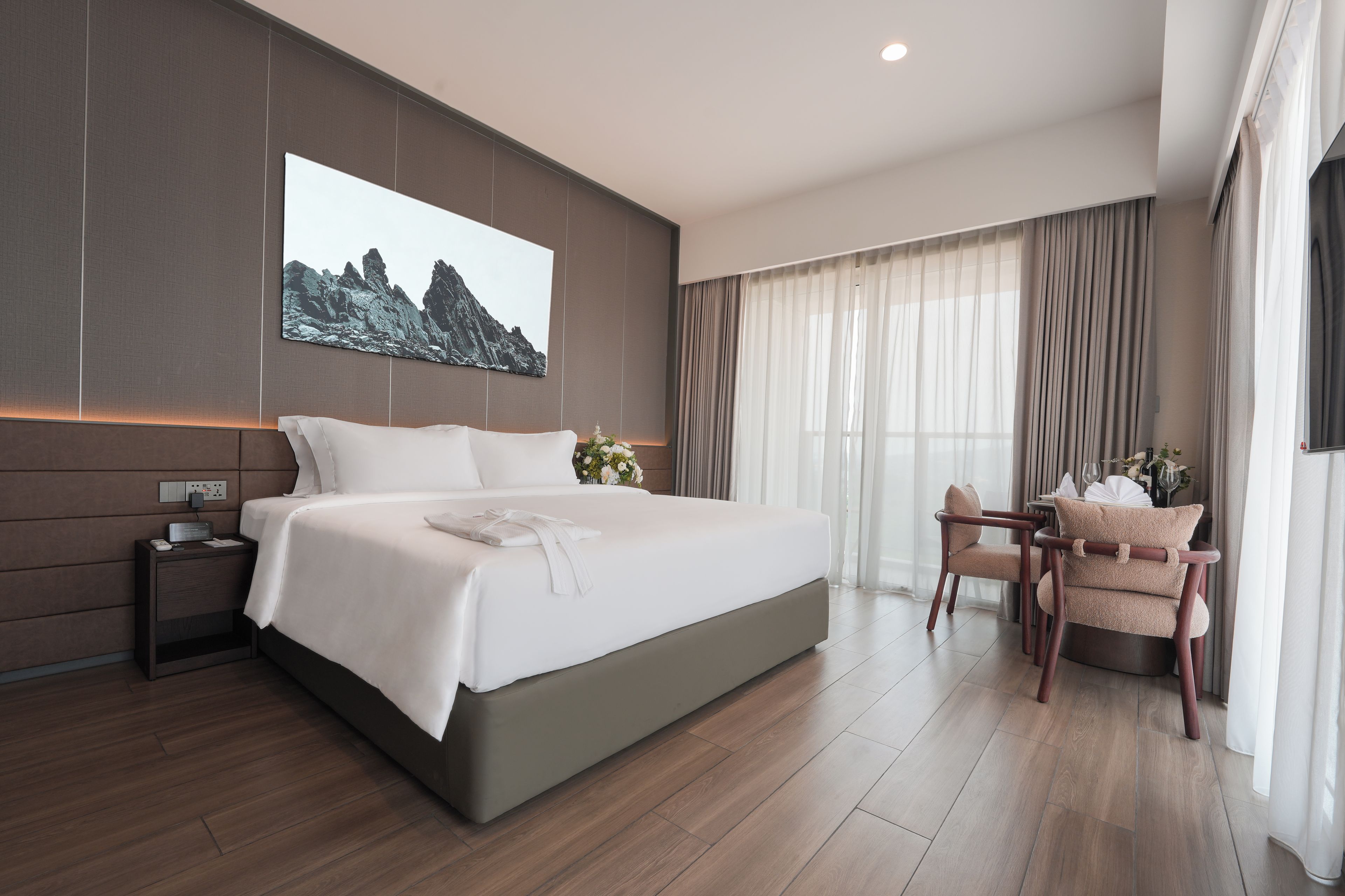 Una habitación de hotel moderna con una cama grande, un escritorio y una silla.