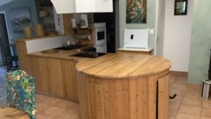 Een keuken met houten aanrecht, een fornuis en een spoelbak.