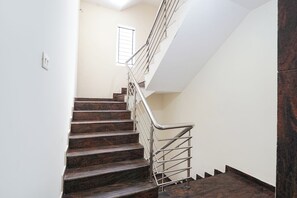 A staircase with wooden steps and metal railings, leading to an upper floor. - Fabhotel Akshaya Residency (Bengaluru)