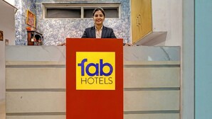 A person standing behind a podium with the 'fab hotels' logo. - Fabhotel Silver Key I (New Delhi)