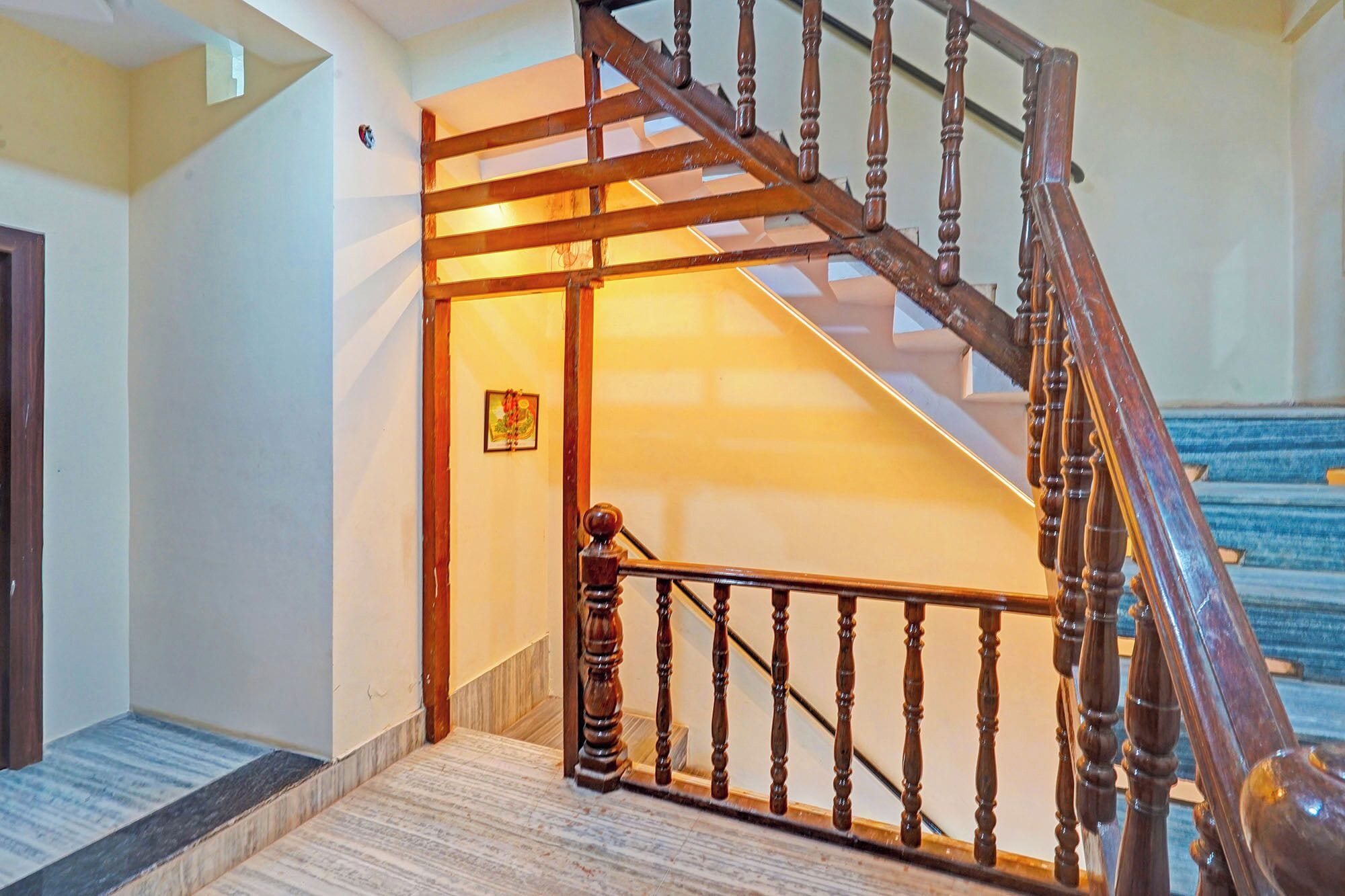 A wooden staircase with a handrail leading to a landing.