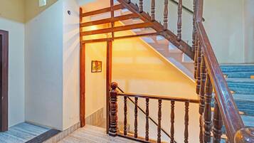 A wooden staircase with a handrail leading to a landing.
