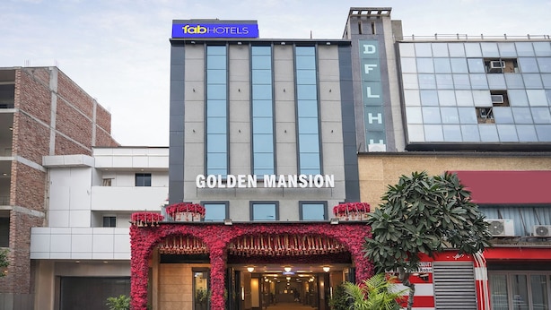 Een hotel genaamd 'Golden Mansion' met een moderne gevel, grote ramen en een opvallend bord.