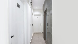 A hallway with white doors, each marked with a number. - Via Lochav Residency (New Delhi)