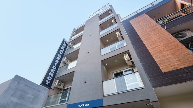 A multi-story hotel with balconies, a visible sign for 'VIA,' and a modern architectural design. - Via Lochav Residency (New Delhi)