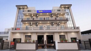 Een meerlaags hotel met een modern gevelontwerp, balkons en airconditioning.