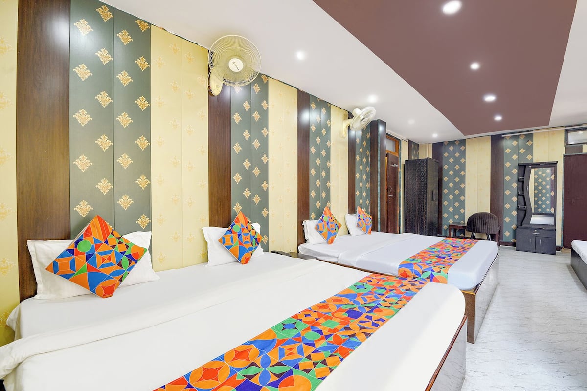 Una habitación de hotel con dos camas, un tapete decorativo alargado y un espejo en la pared.
