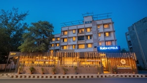 Un edificio a più piani con un'insegna per 'fabHOTELS' e il 'Ristorante Familiare Suruchi Homes'.