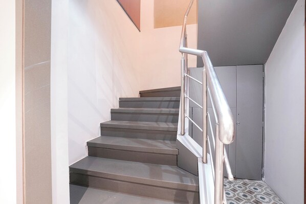 A staircase with metal railings and a patterned floor.