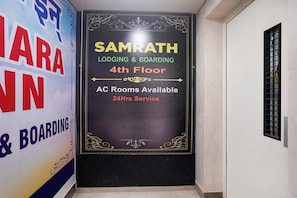 A sign for Samrath Lodging & Boarding on the 4th floor with AC rooms available and 24-hour service. - Fabhotel Samrath (Mumbai)
