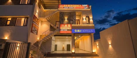 A building with 'AS RESIDENCY LUXURY ROOMS' signage, a staircase, and a 'fab hotels' sign.
