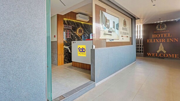 A hotel reception area with a check-in counter, a reception desk, and a welcome sign. - Fabhotel Elixir Inn (Surat)