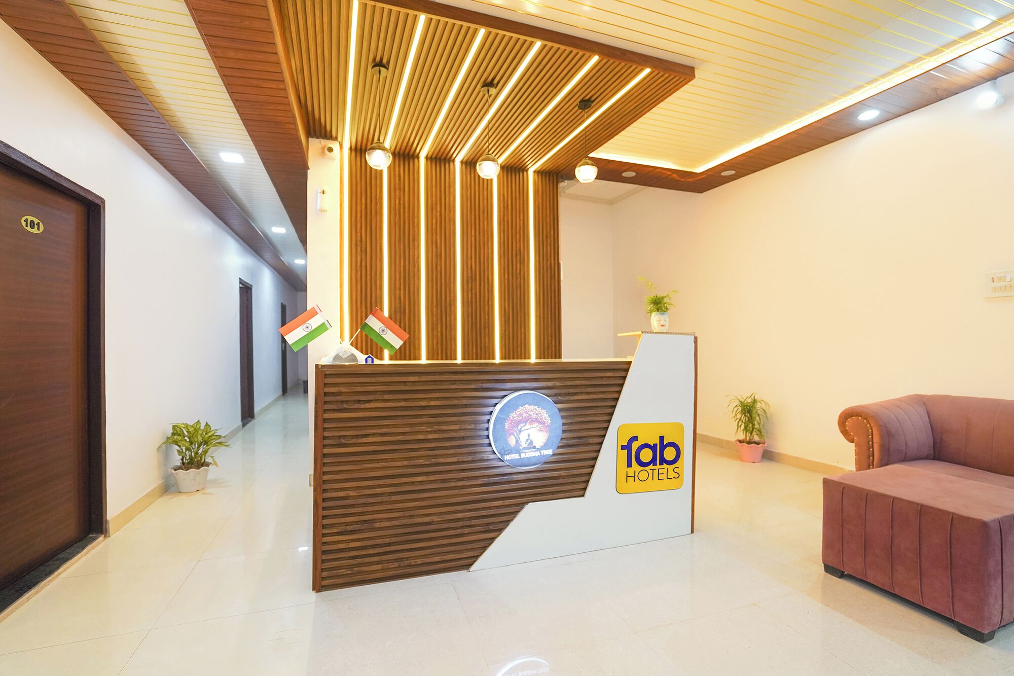 Un mostrador de recepción de hotel con un diseño moderno, que cuenta con una zona de madera, un logotipo y dos banderas.