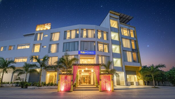 Um hotel moderno com fachada imponente, vários andares e entrada bem iluminada.