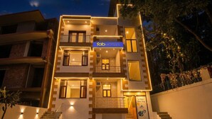 A modern building with a sign reading 'fab hotels,' featuring multiple balconies, a staircase, and a patterned tiled entrance. - Fabhotel 9 Palm (Dehradun)