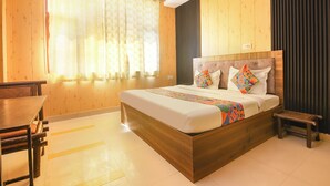 A hotel room with a wooden bed, a desk, and a chair. - Fabhotel 9 Palm (Dehradun)