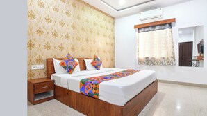 Une chambre moderne avec un lit en bois, un papier peint à motifs, un appareil de climatisation et une fenêtre donnant sur l’extérieur.