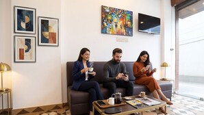 Une salle d’attente avec un sol à motifs, une table basse avec un magazine et un téléviseur fixé au mur.