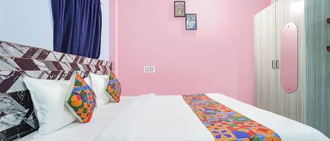 Un dormitorio con cama, almohadas, armario y puerta.