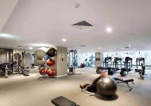 A gym with various exercise equipment, including treadmills, stationary bikes, and free weights. - Chic & Cozy 2BR Apartment Close to Vic Market (Melbourne)