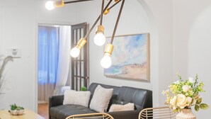 Un salon moderne avec un canapé, une table à manger et un vase de fleurs.