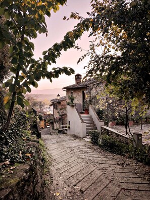 A stone staircase leading to a rustic building with a stone roof, surrounded by greenery and a view of distant hills. - Residence in Penna with 1 bedrooms sleeps 2 (Penna)