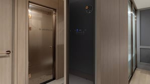 Un ascenseur moderne doté d’un écran numérique et d’une porte portant l’inscription « H AVENUE ».