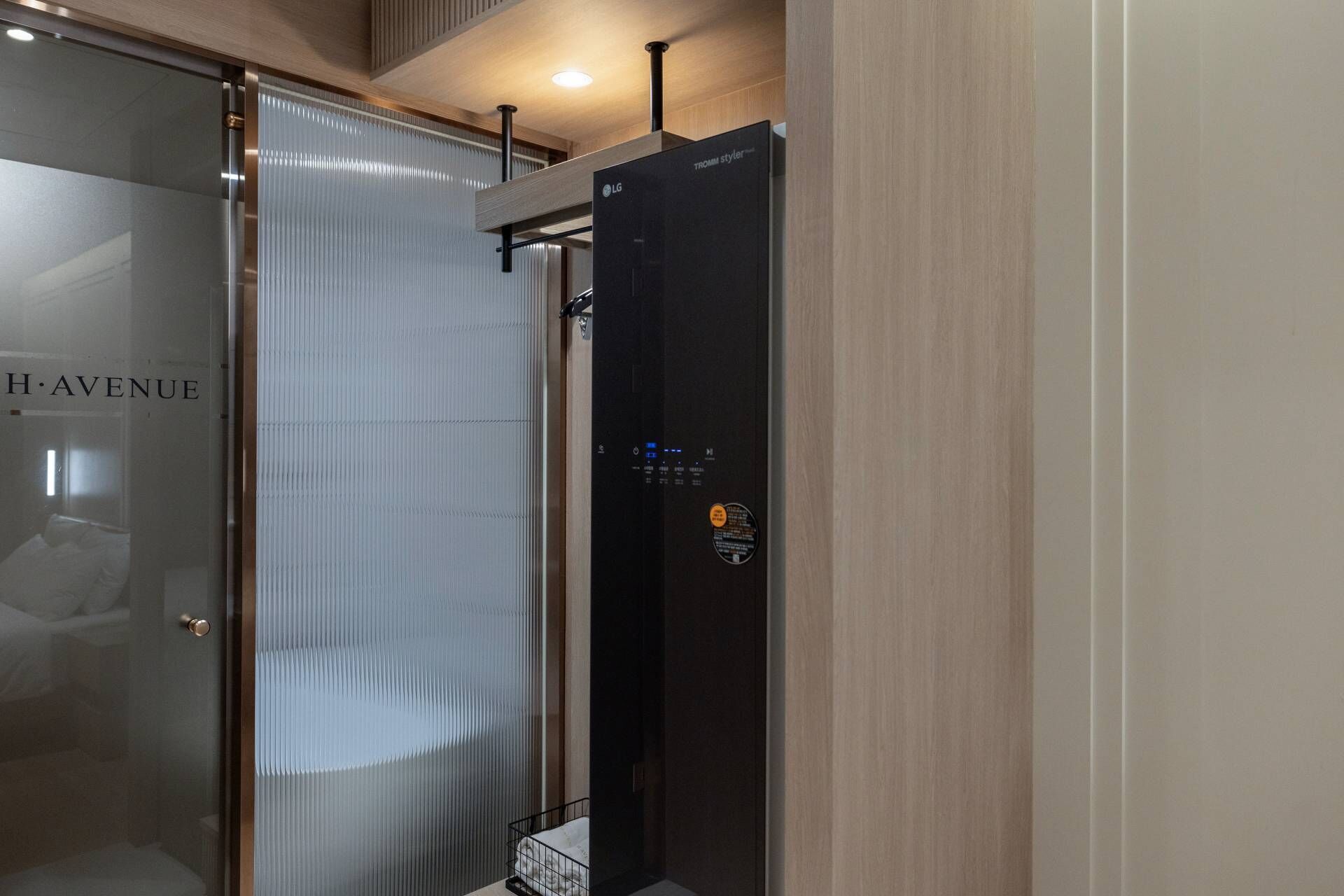 A modern bathroom with a glass door, a black towel rack, and a mirror.
