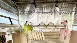 A compact kitchen with a sink, dish rack, and a small countertop. - K INN 55 (George Town)