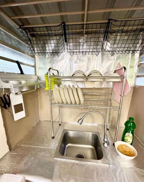 A compact kitchen with a sink, dish rack, and a small countertop. - K INN 55 (George Town)