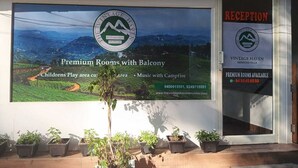 A sign for Vintage Haven, a serviced villa, advertising premium rooms with a balcony, a children's play area, and music with campfire. - The Vintage Haven Munnar (Udumbanchola)