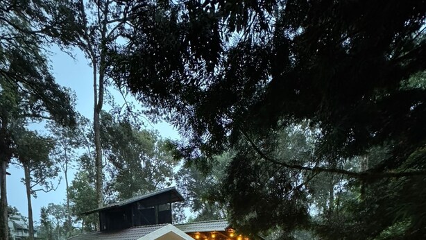 A two-story house with a balcony, a covered patio, and a staircase leading to the upper floor. - The Vintage Haven Munnar (Udumbanchola)