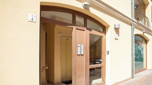 L'ingresso di un edificio con una porta in vetro, una targa con il numero '4' e una telecamera di sicurezza sopra la porta.