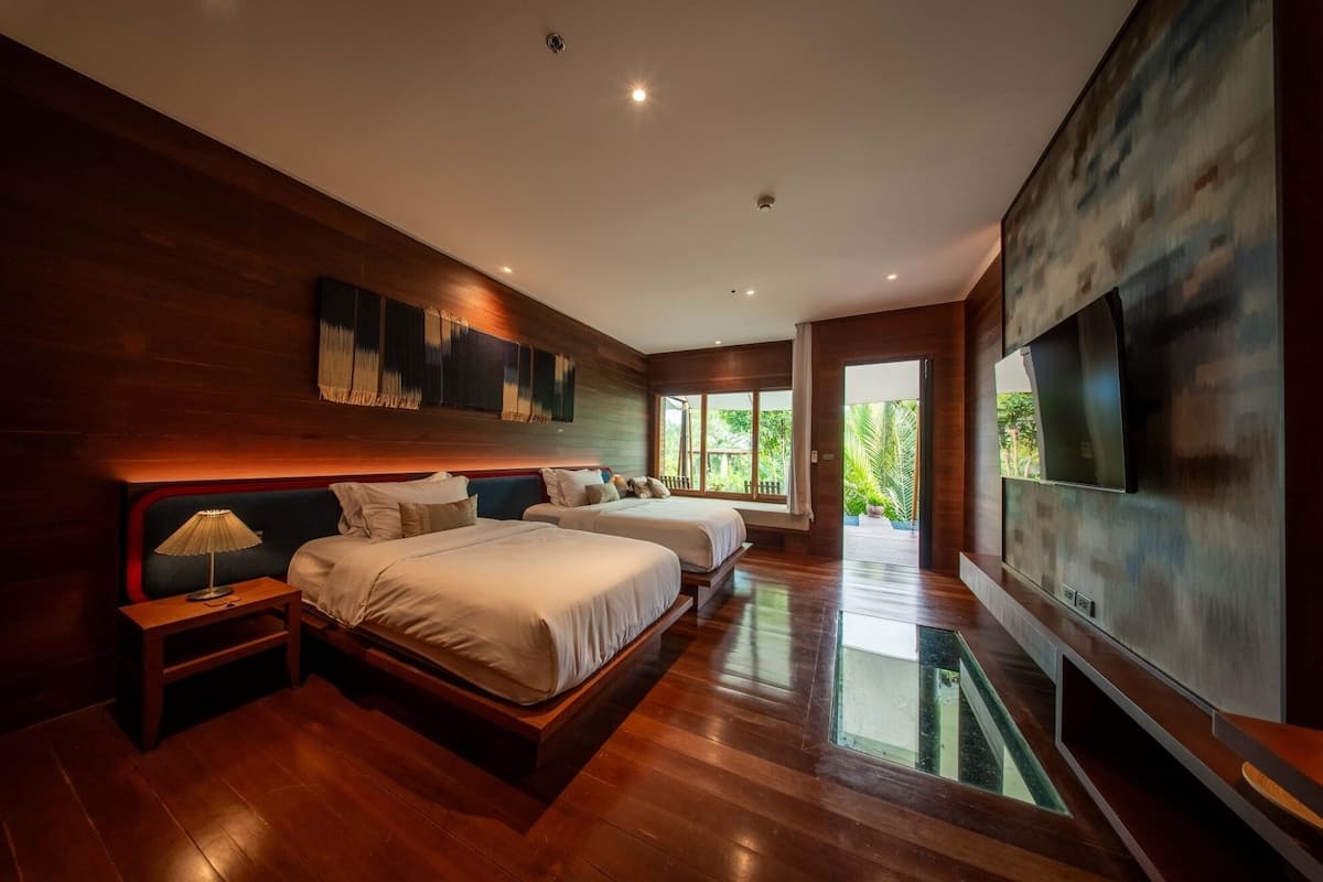Een moderne hotelkamer met een groot bed, een televisie en uitzicht op groen.