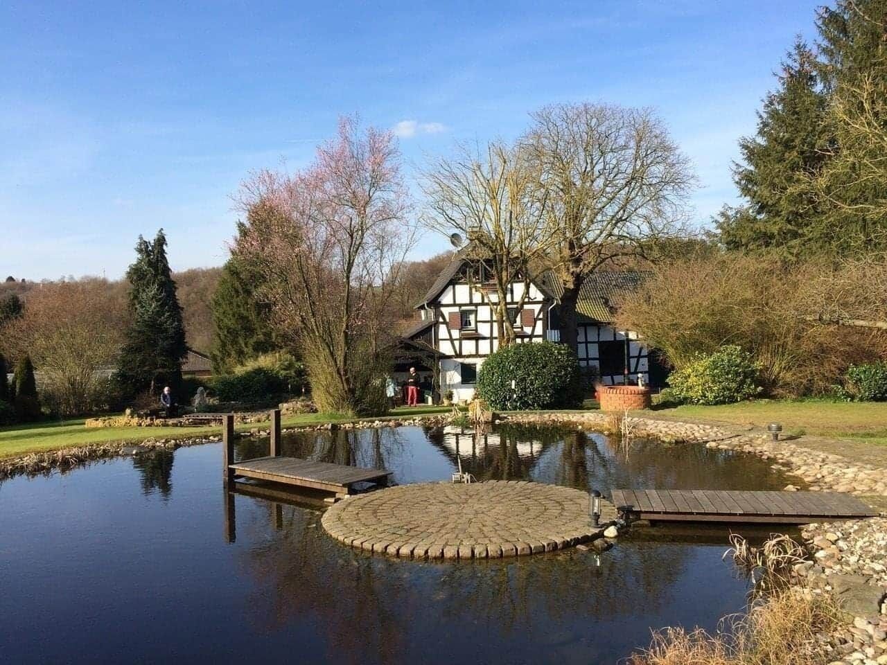 Uma casa tradicional em estilo de colunata com lago e docas de madeira.