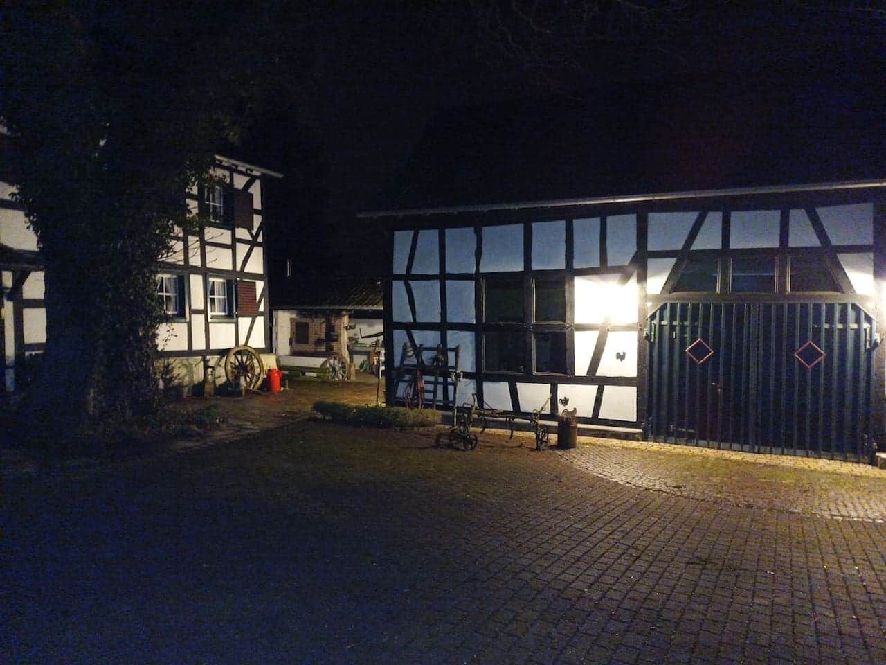 Een klassiek gebouw met een groot raam en een hekpoort, 's nachts.